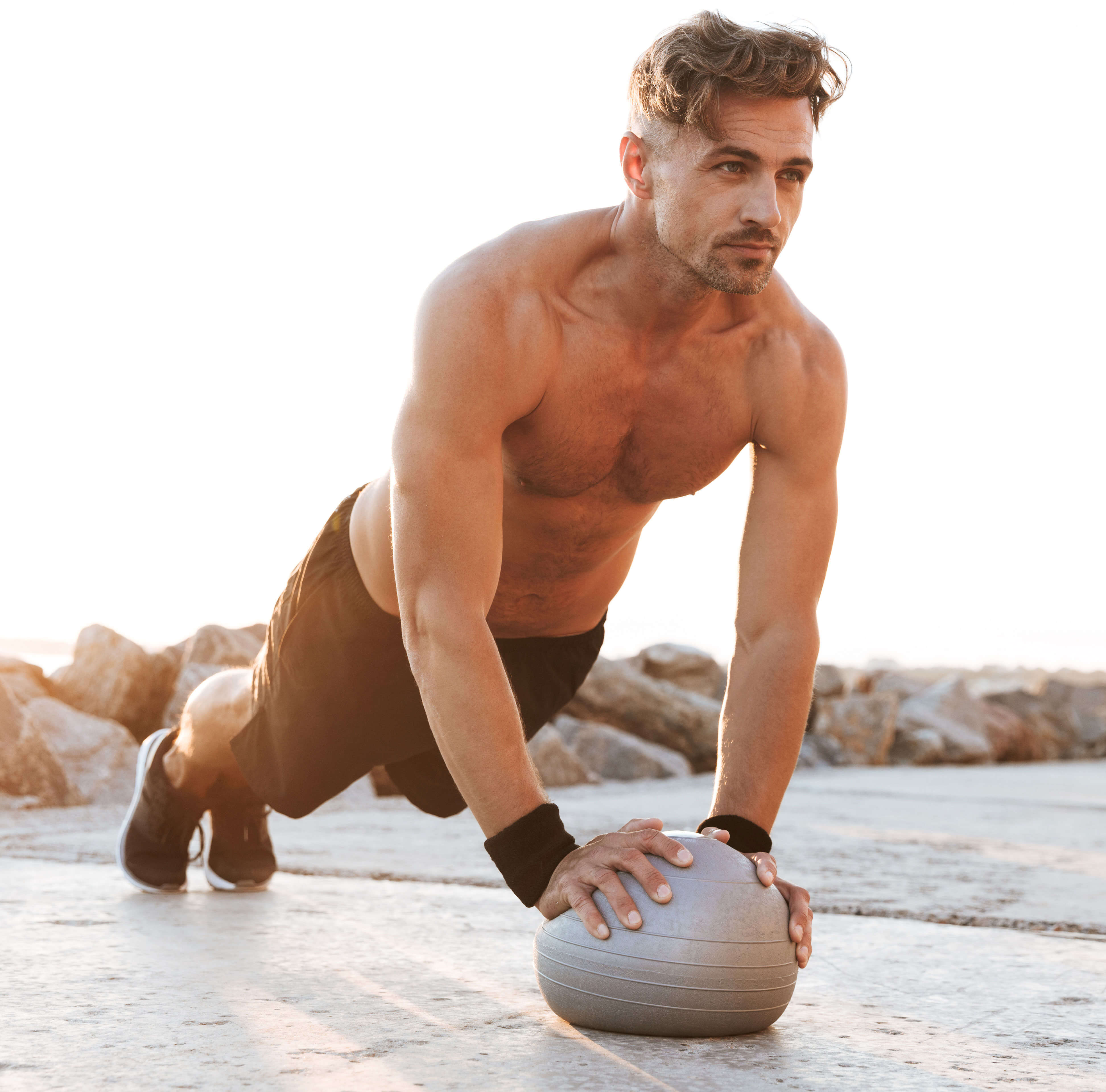 Image of a fit man doing push ups with a medicine ball