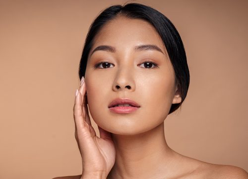 Photo of a woman with radiant skin touching her face