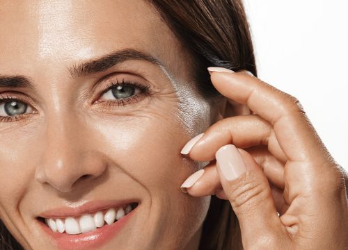 Photo of a smiling woman with fine lines & wrinkles around her eyes