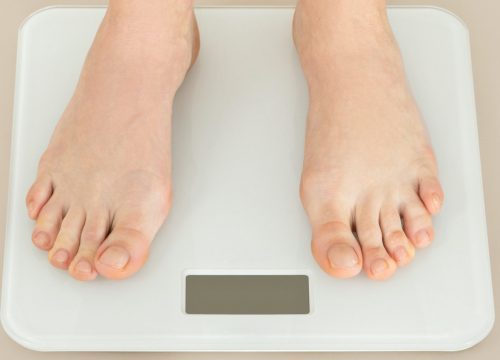 Photo of a person's feet on a scale for weight loss